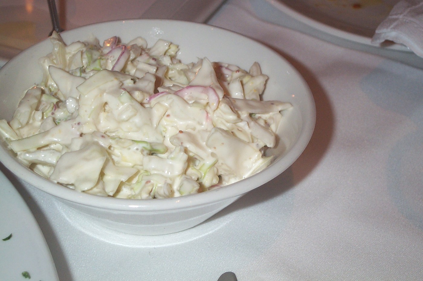 Kefires öntettel készült, krémes fehér káposztasaláta (coleslaw) fehér tálban