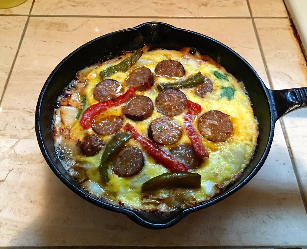 Frittata öntöttvas serpenyőben, kolbászkarikákkal és paprikával